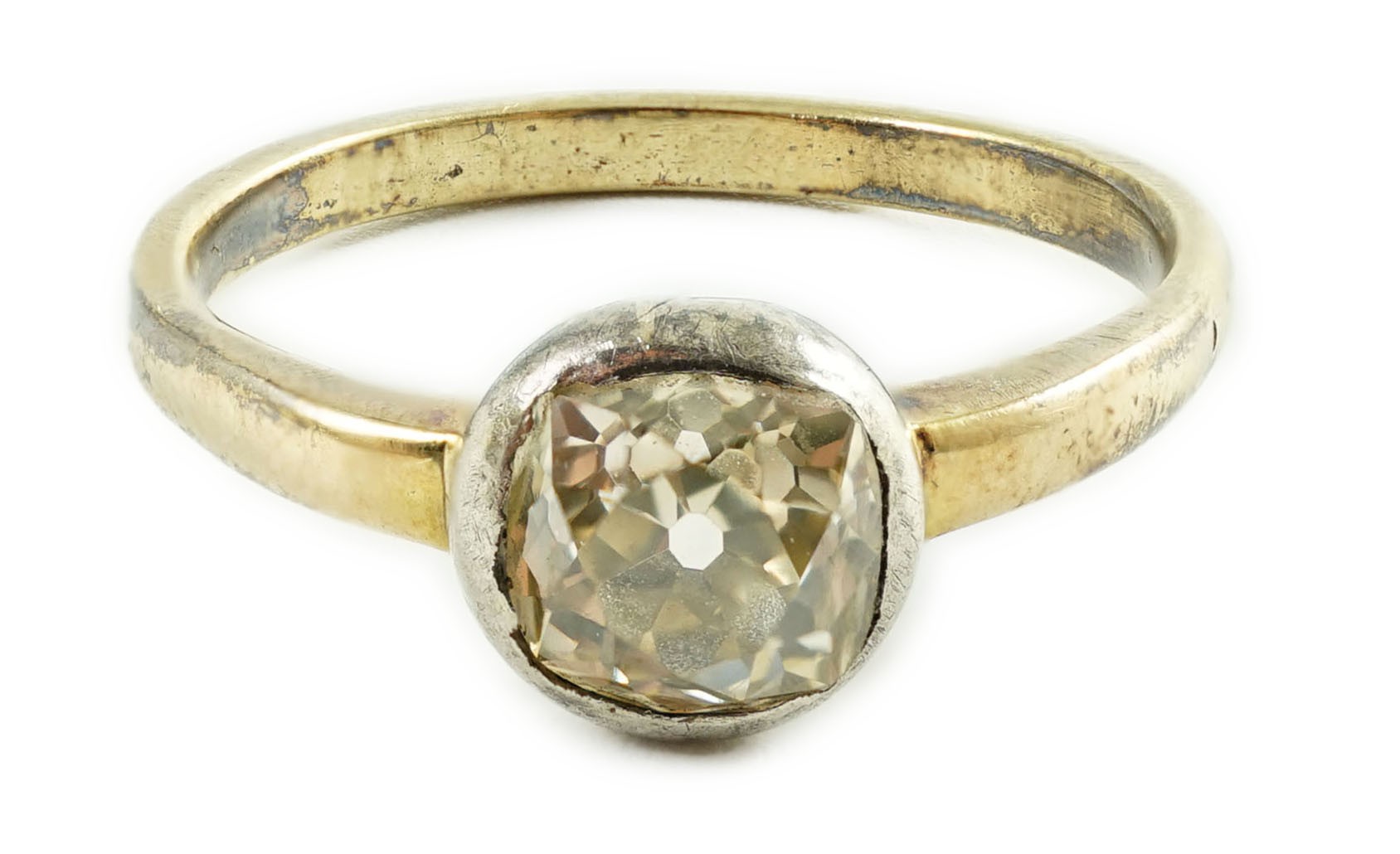 An antique yellow metal and collet set solitaire old cushion cut diamond ring